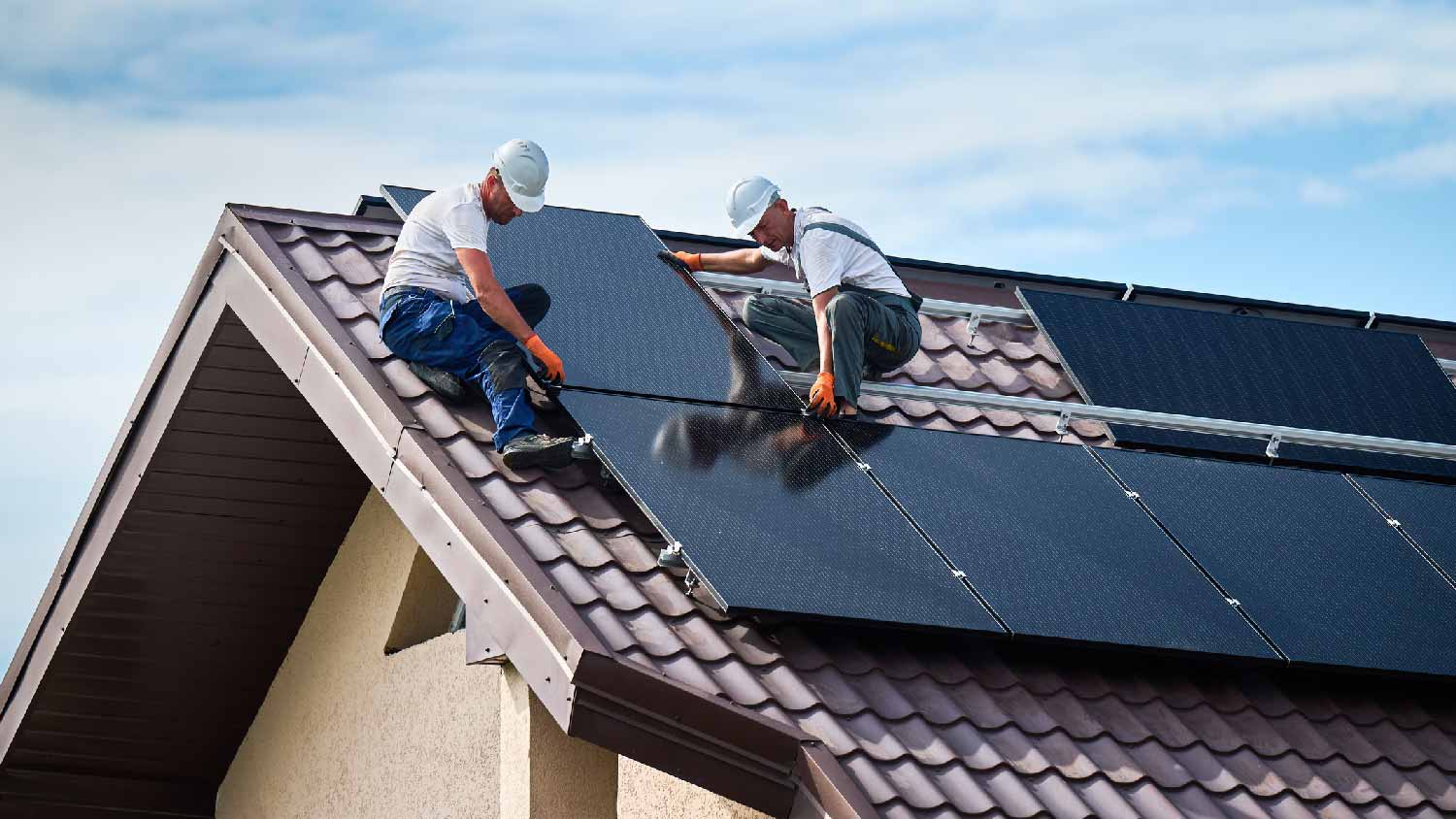 Professionals installing solar panels on a roof