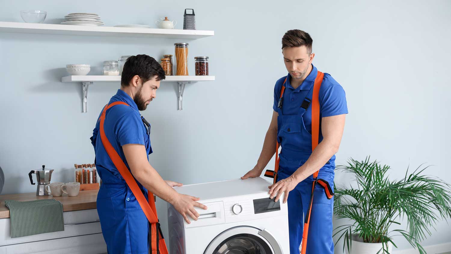 Two professionals moving a washer from a room