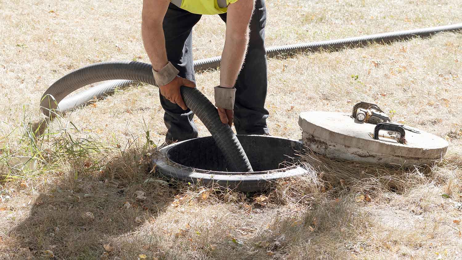Worker pumping a residential septic tank