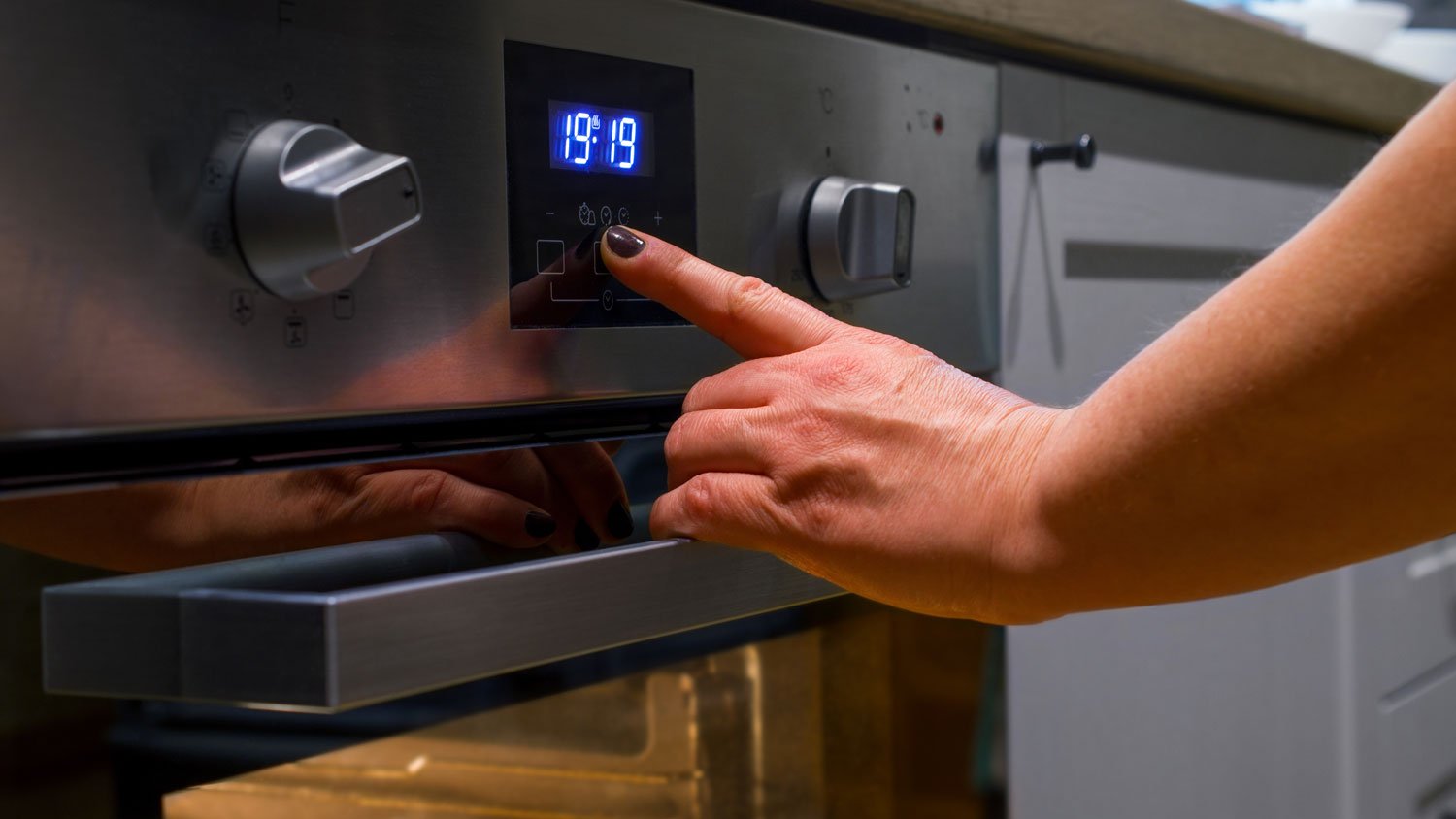 Woman pushing a button on an oven