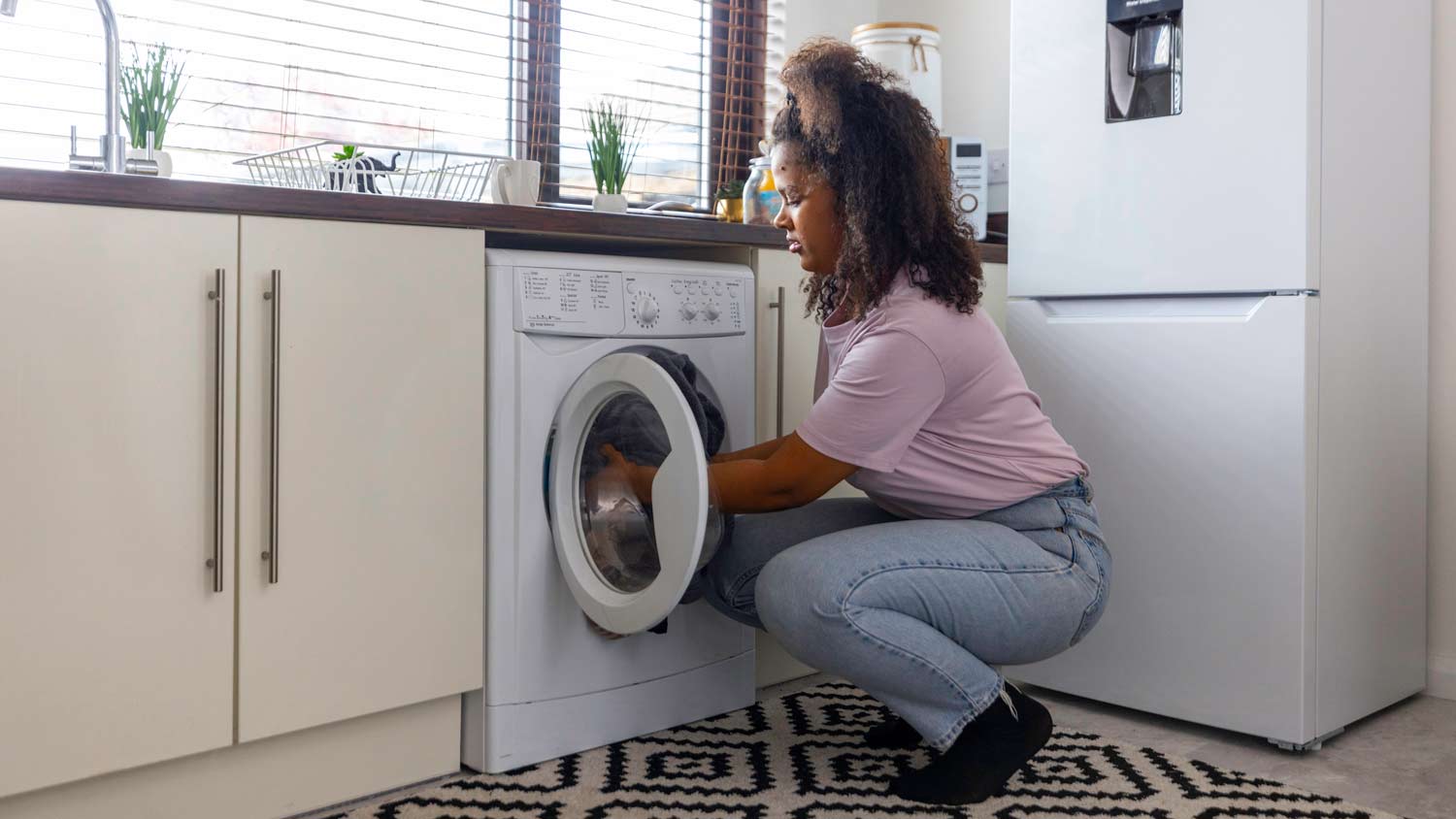 woman putting clothes in wash