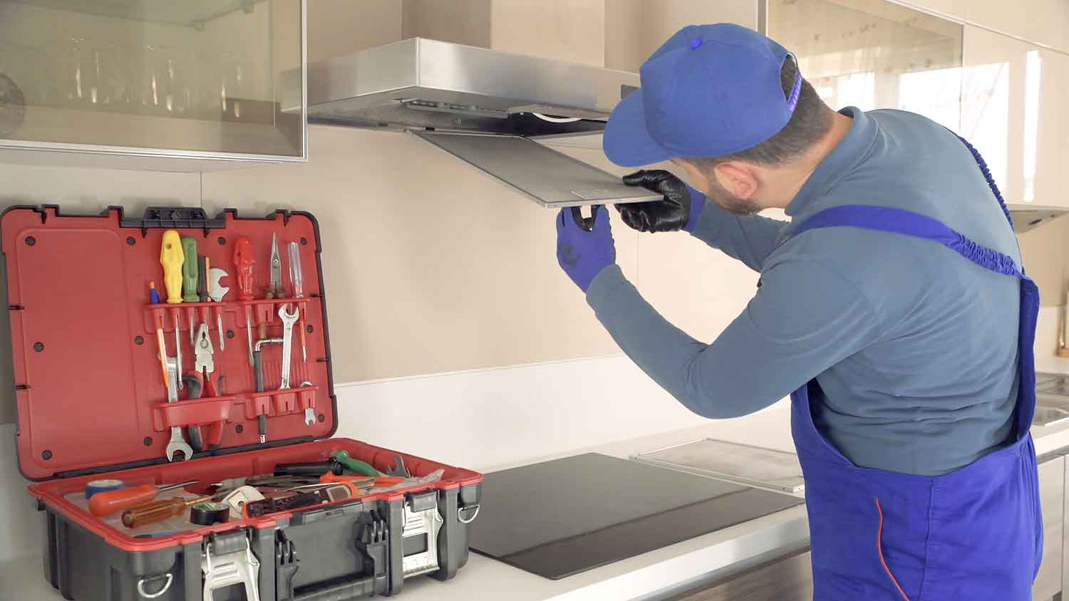 Technician installing range hood in the kitchen