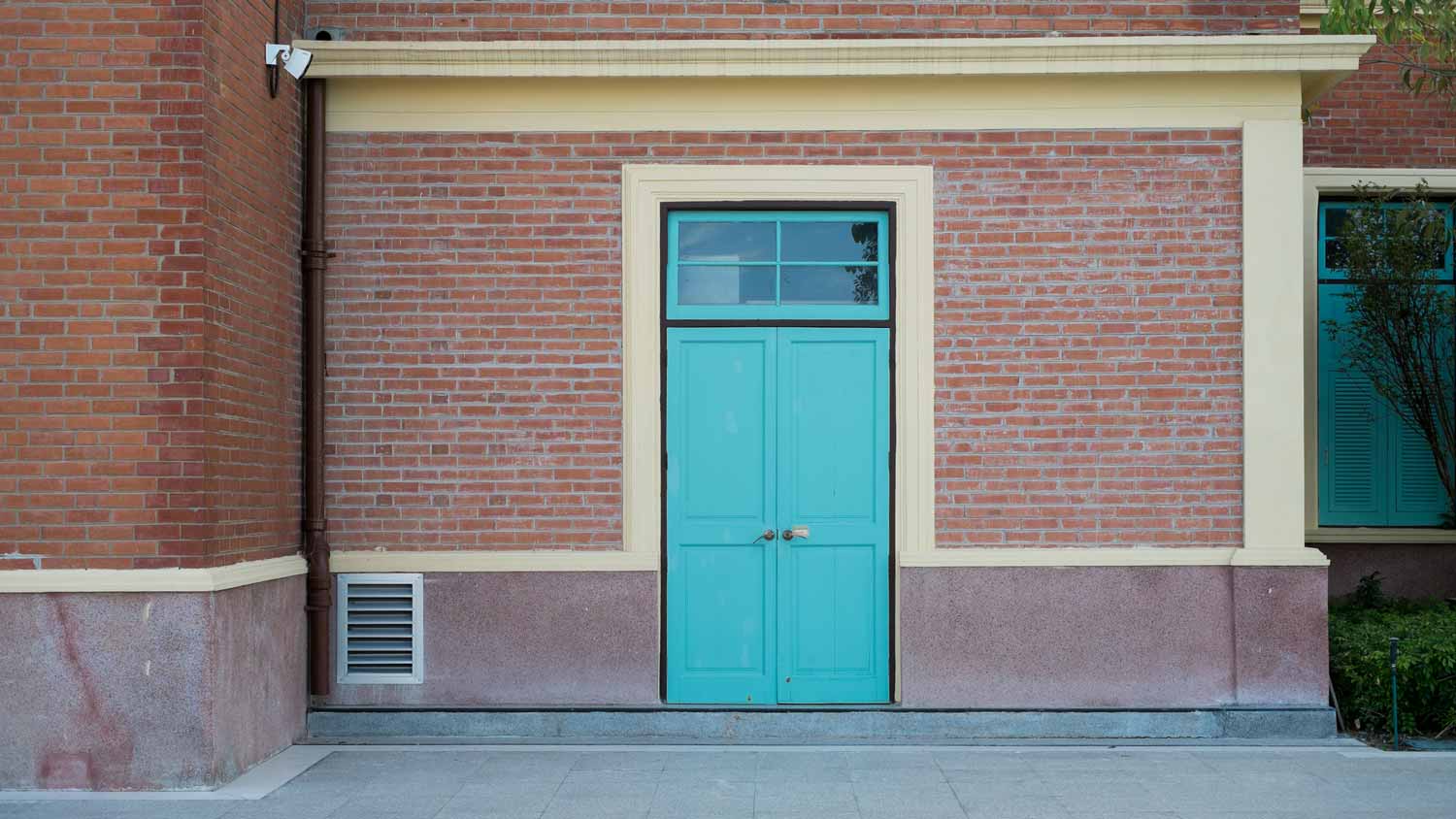 A red brick house with a teal front door