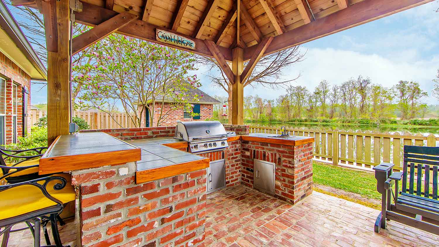 Red brick outdoor kitchen on a covered patio