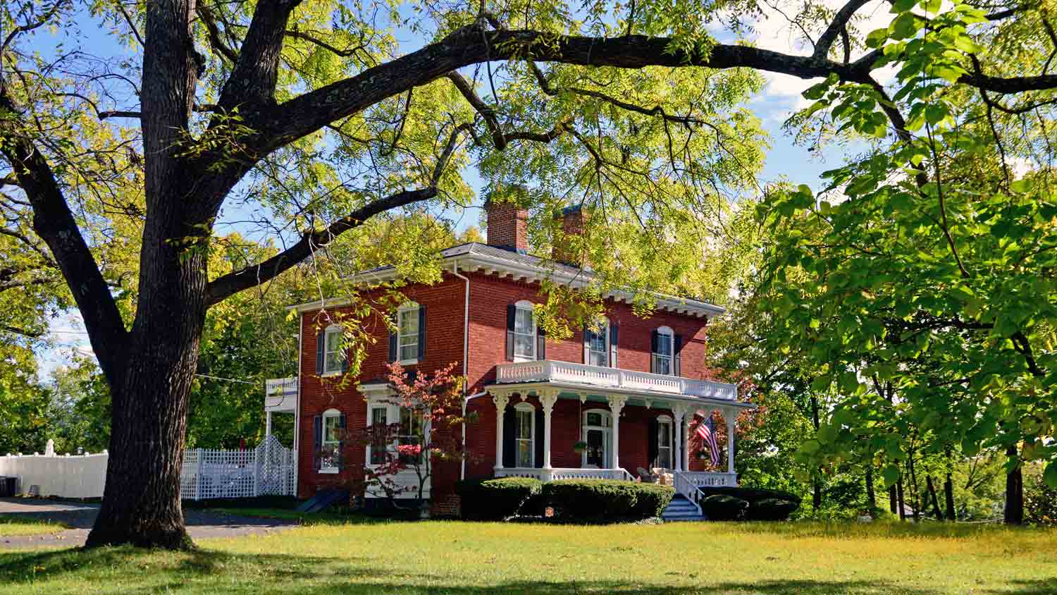 red house with large tree in front
