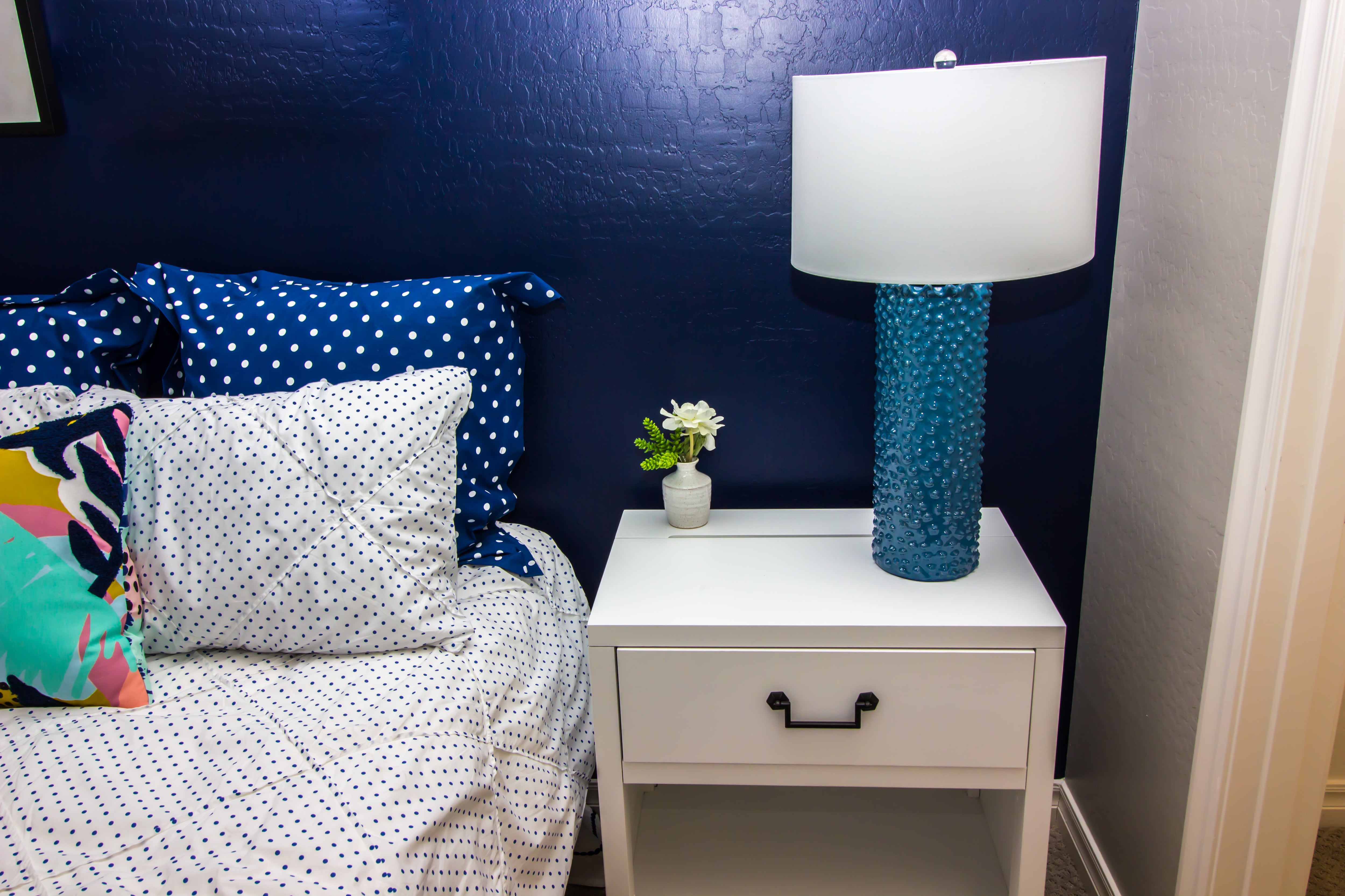 A bedroom with a blue high gloss paint accent wall