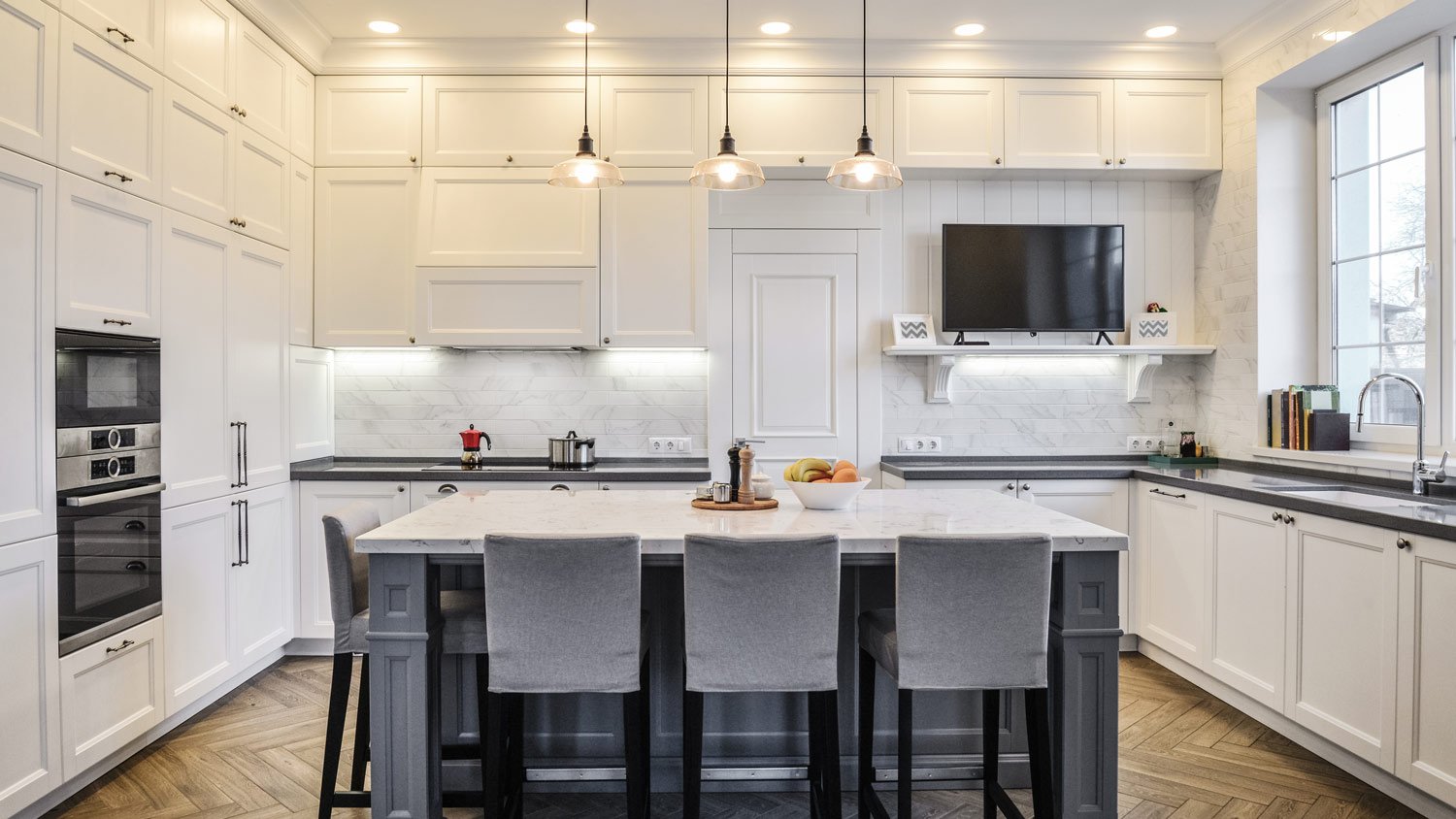 Remodeled modern kitchen with white paneled cabinets floor to ceiling