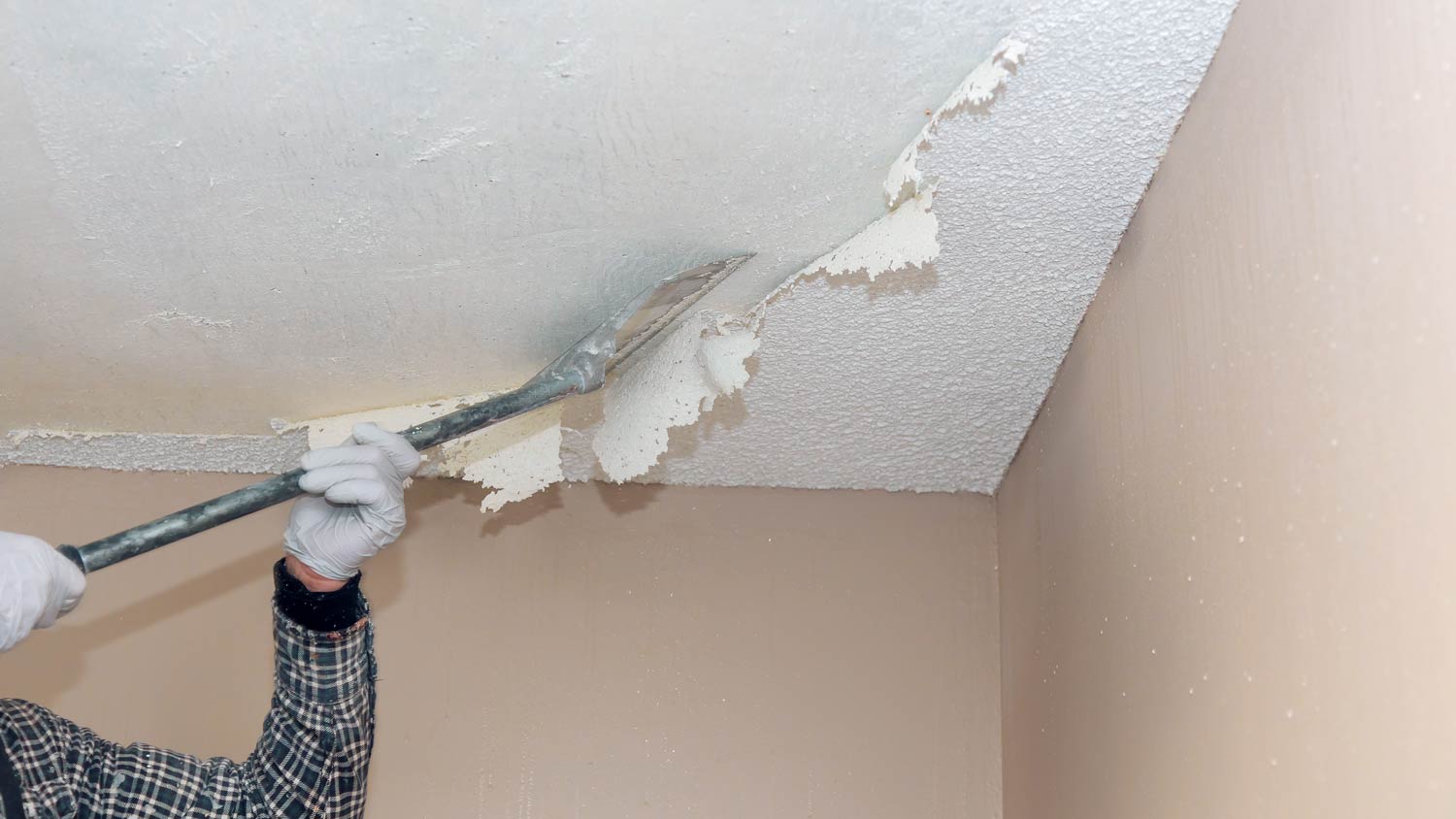 man removing textured popcorn ceiling