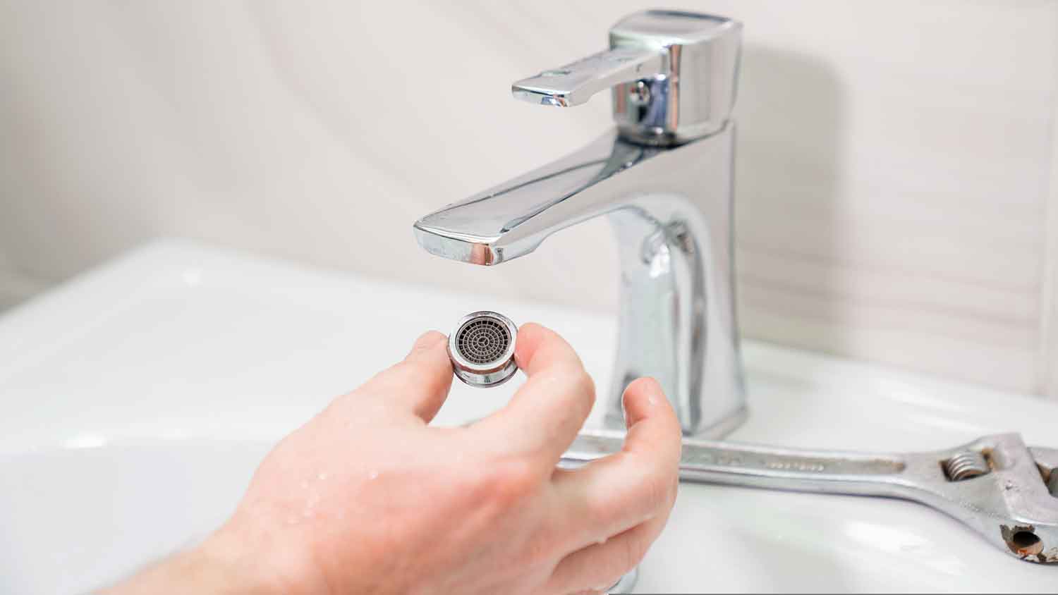 Hand holding bathroom faucet aerator