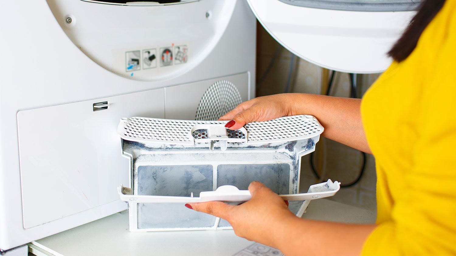 woman removing lint from dryer filter 