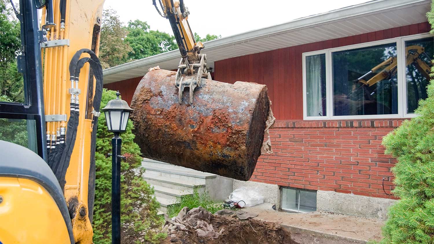 A machine removes an underground oil tank