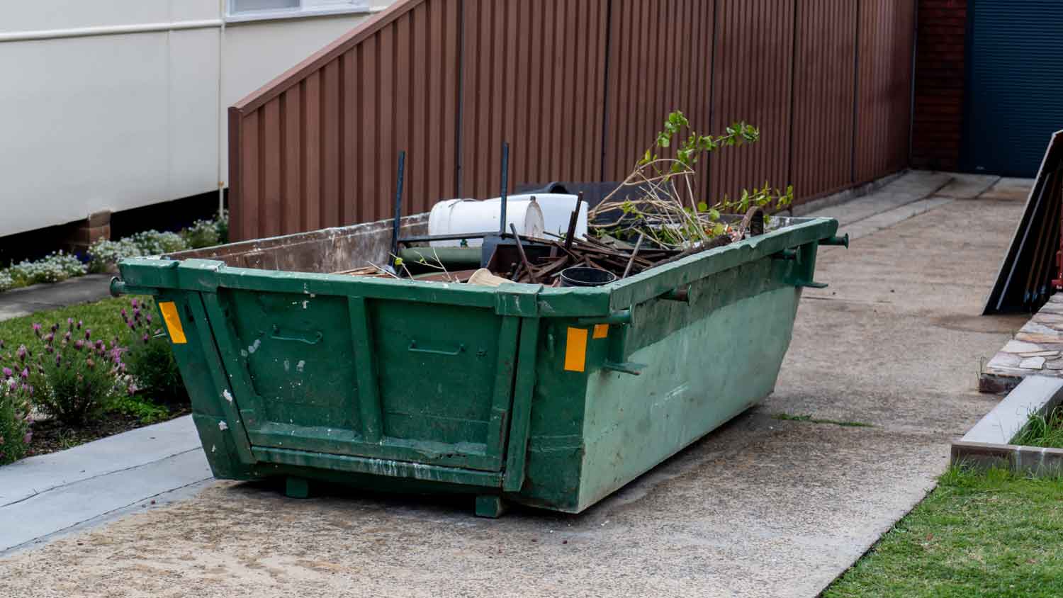 A rented dumpster on the driveway of a house