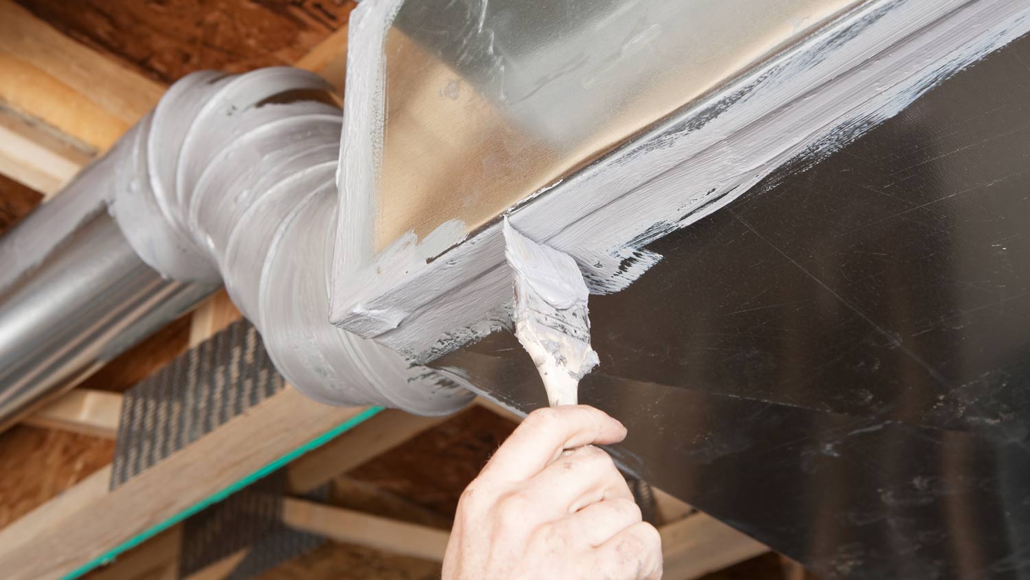 man repairing leak in duct