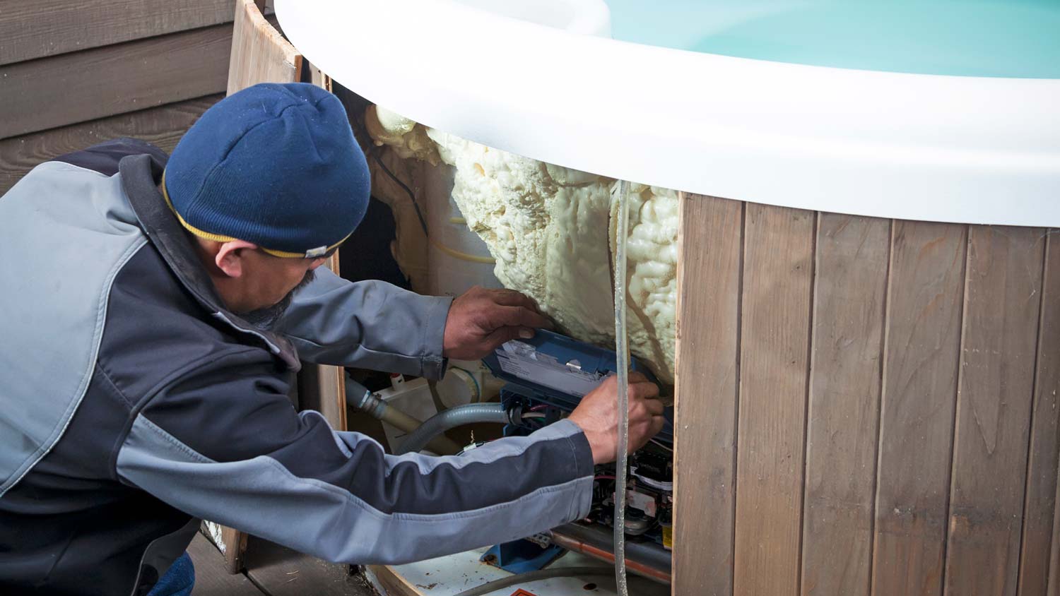 man repairing outdoor hot tub