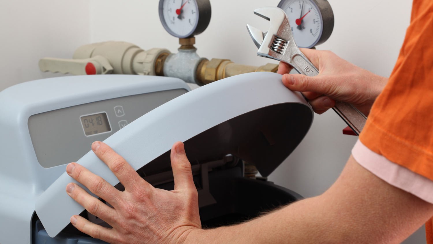 man repairing water softener