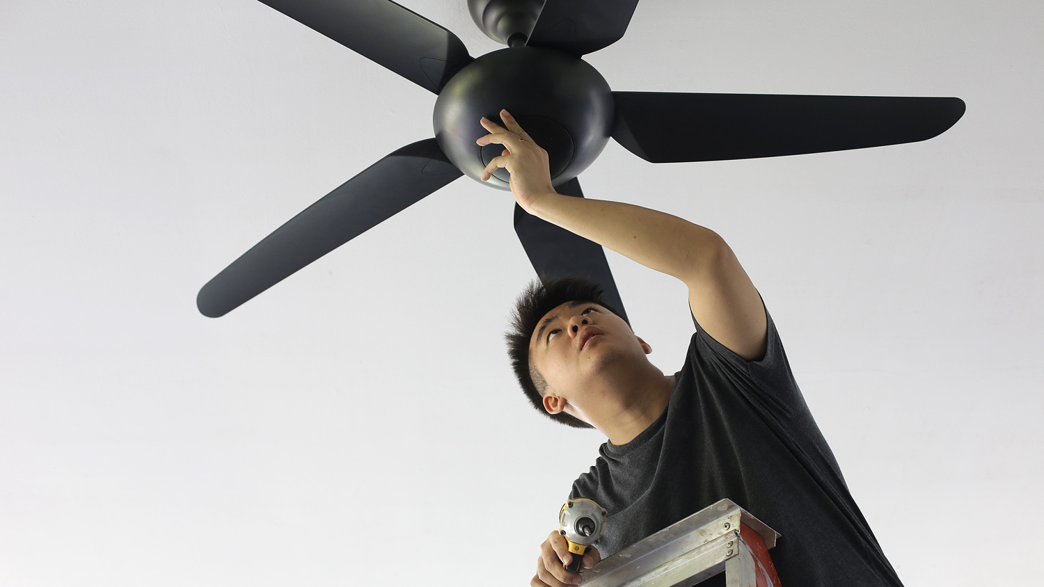 Man repairing ceiling fan