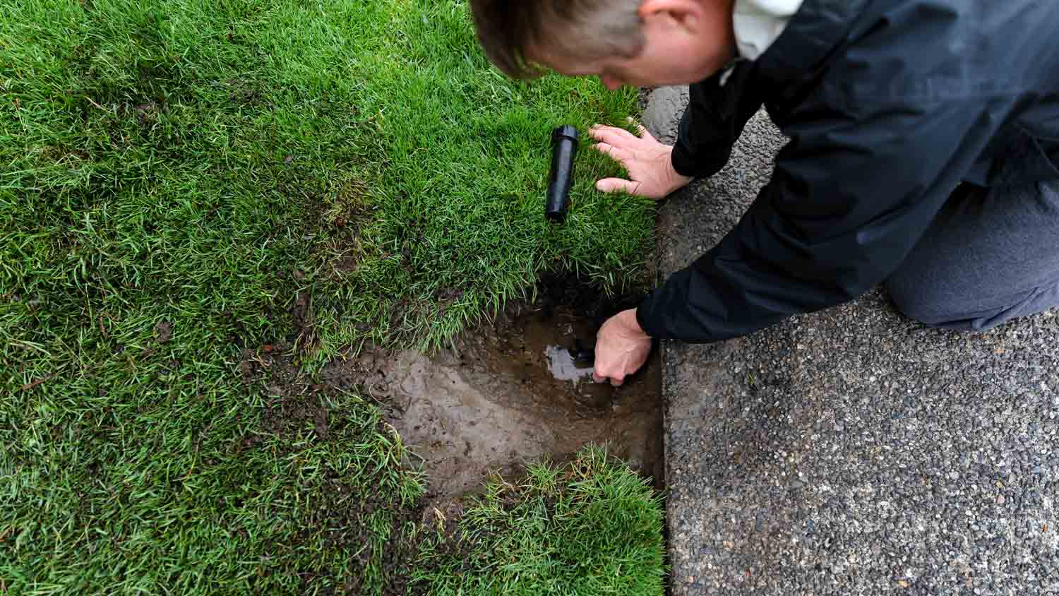 man repairing sprinkler system