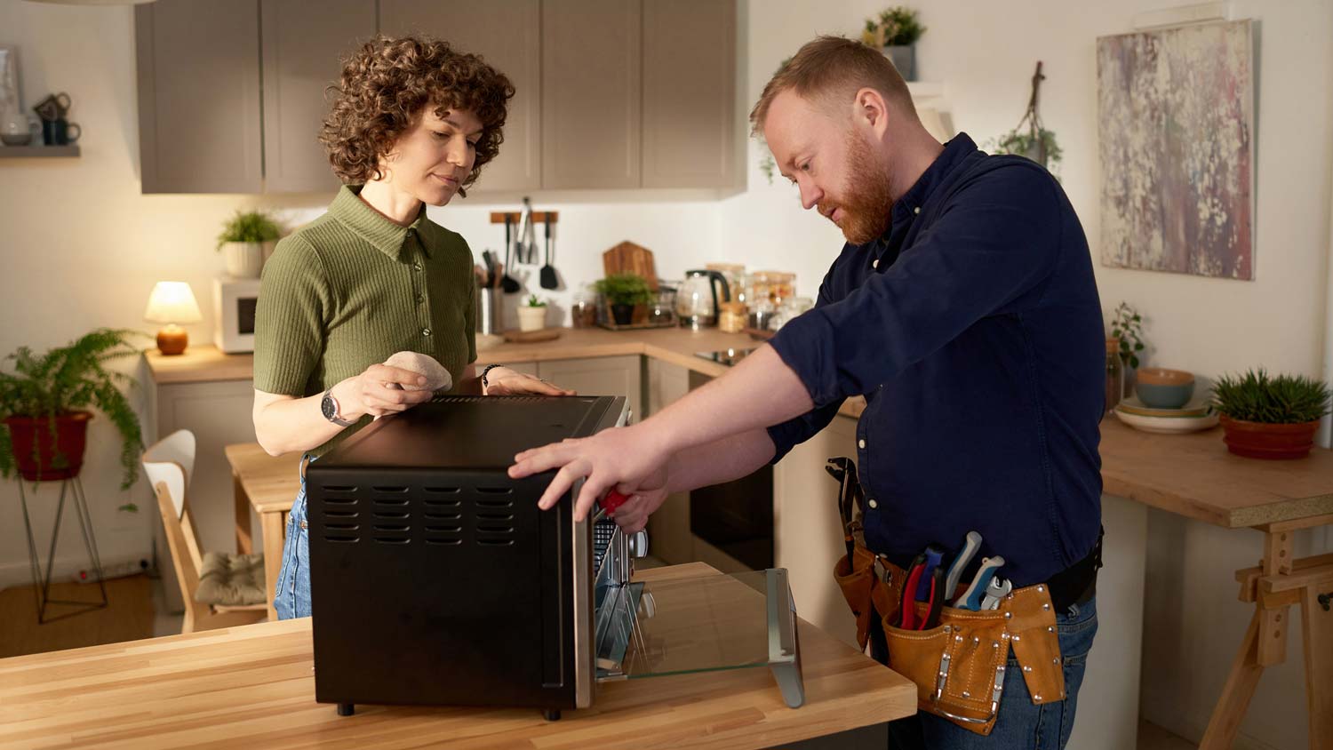 A repairman fixing a microwave 