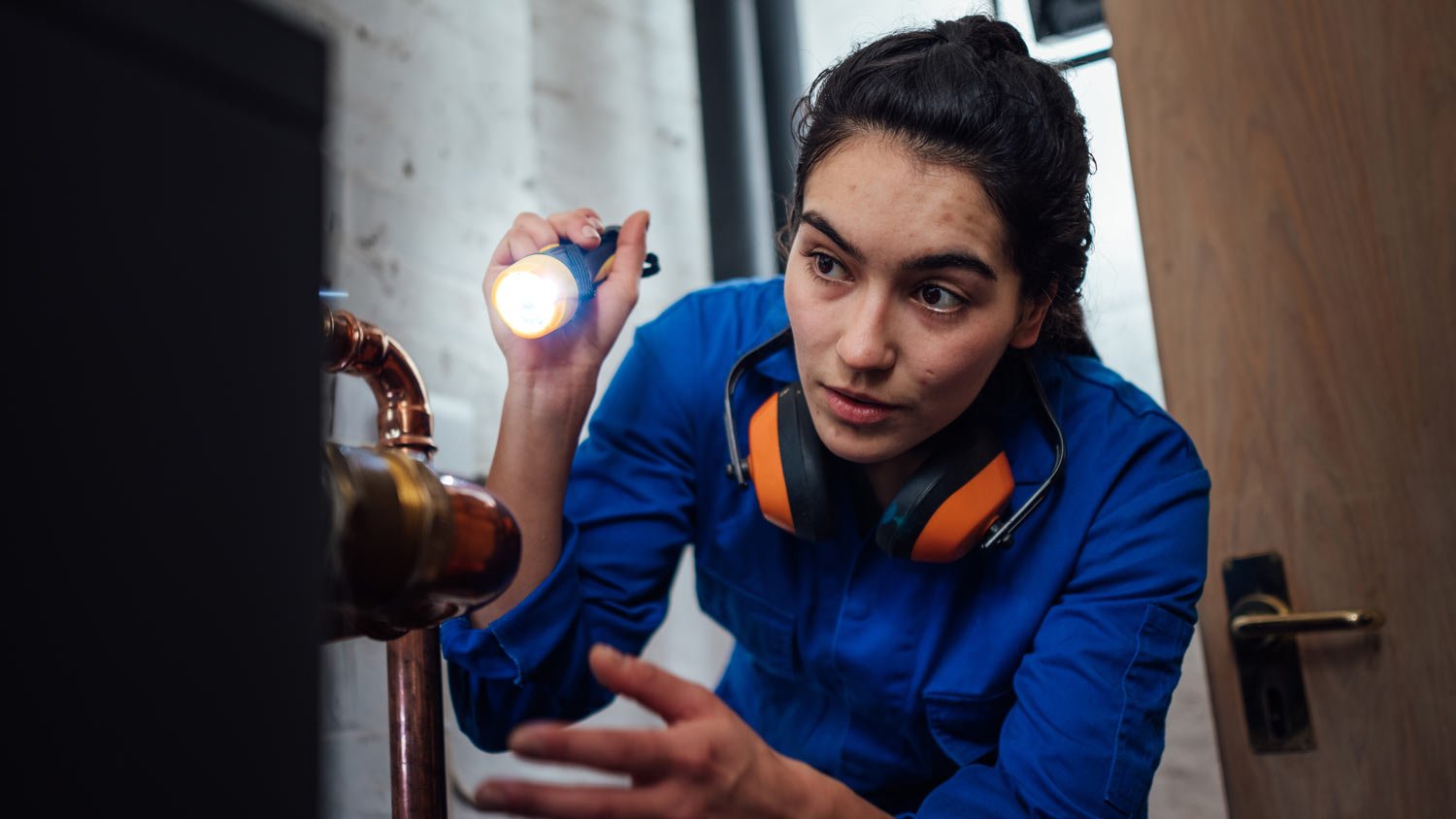 Repairwoman inspecting pipes