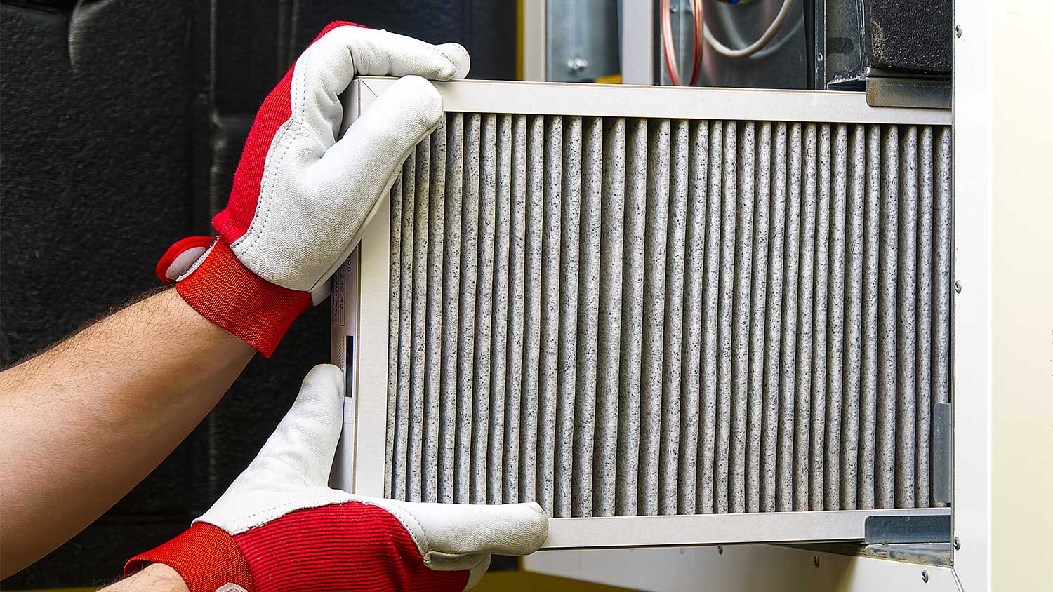 Hands replace an air filter