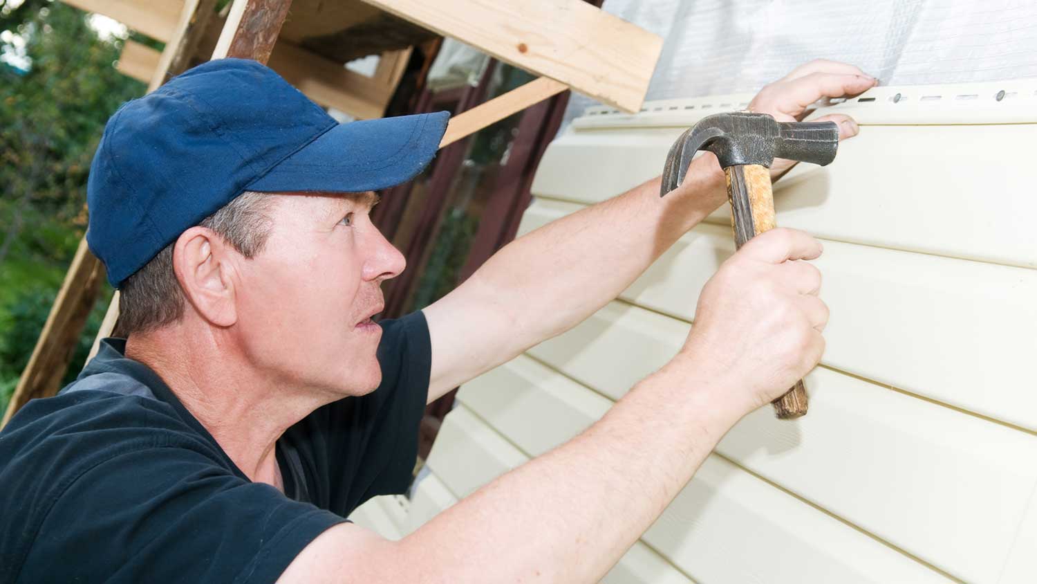 Handyman replacing broken section of siding