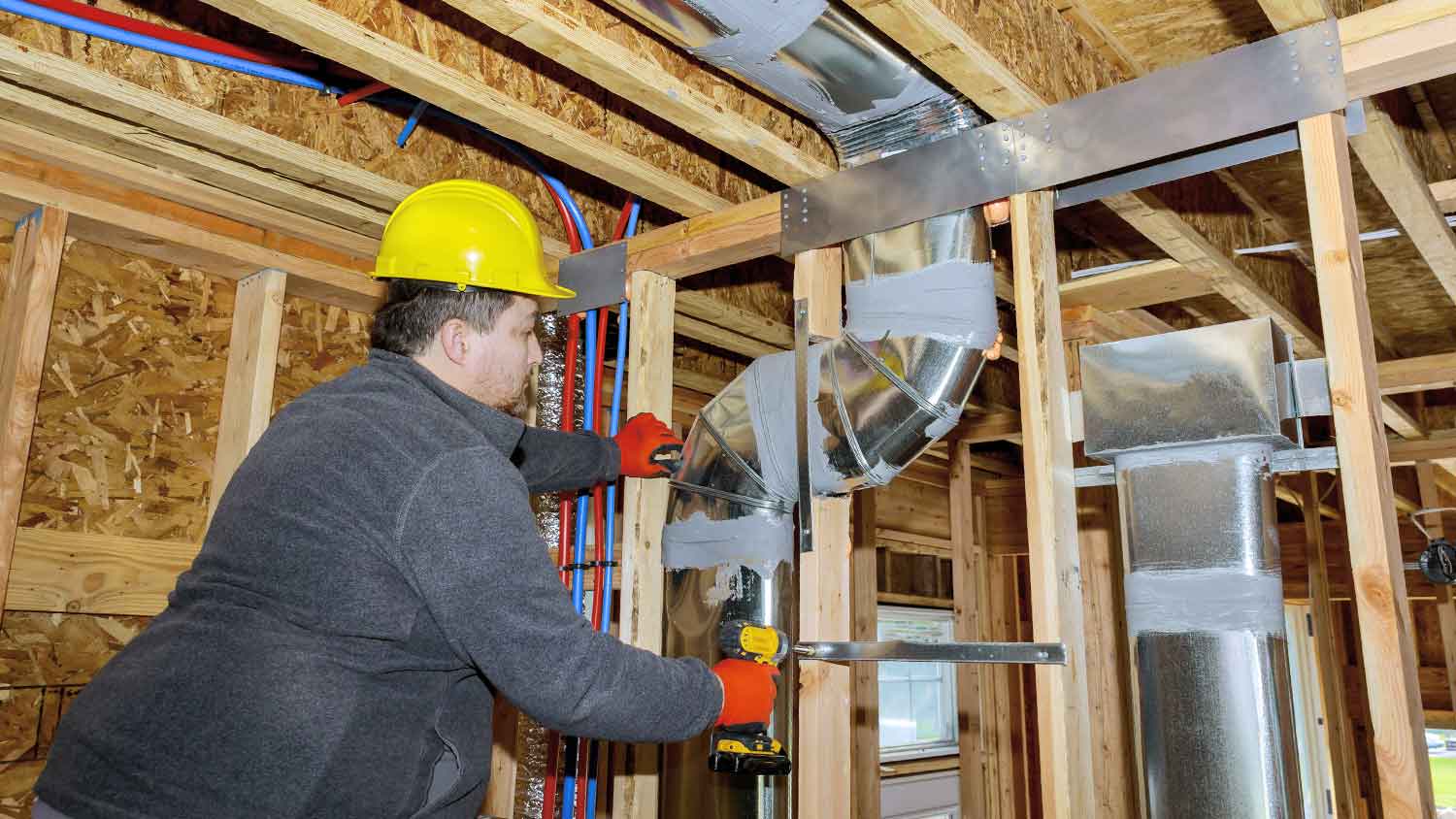 Worker installing residential airduct system