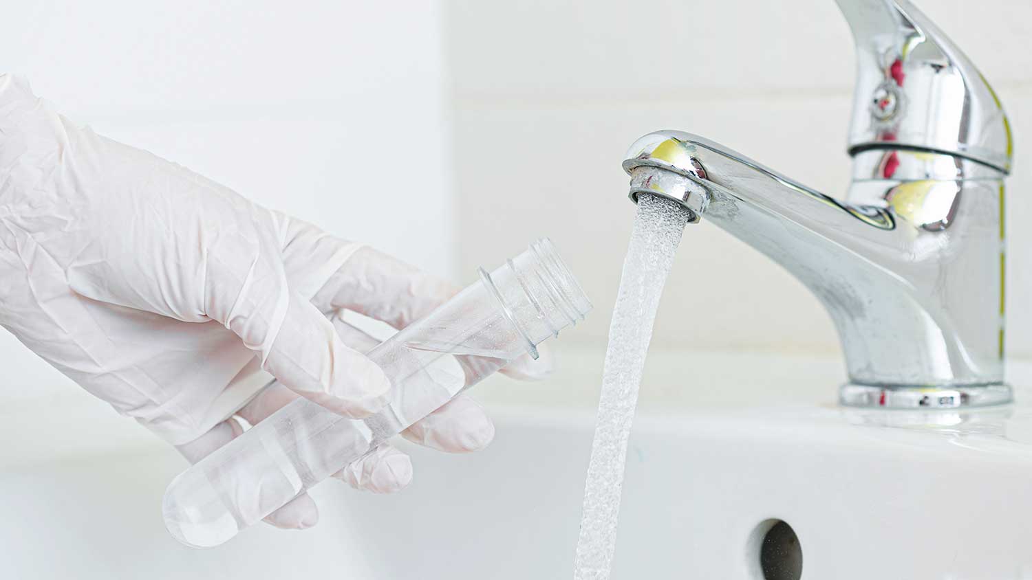 Person collecting water sample from the faucet