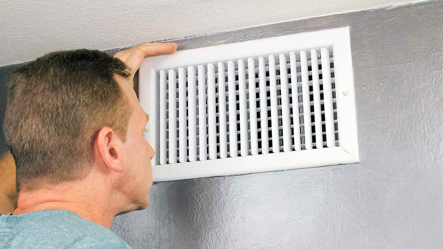 Man checking return air vent