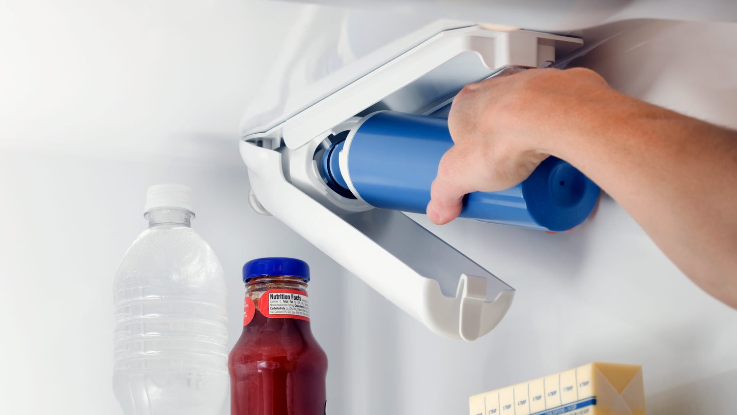 woman changing fridge water filter