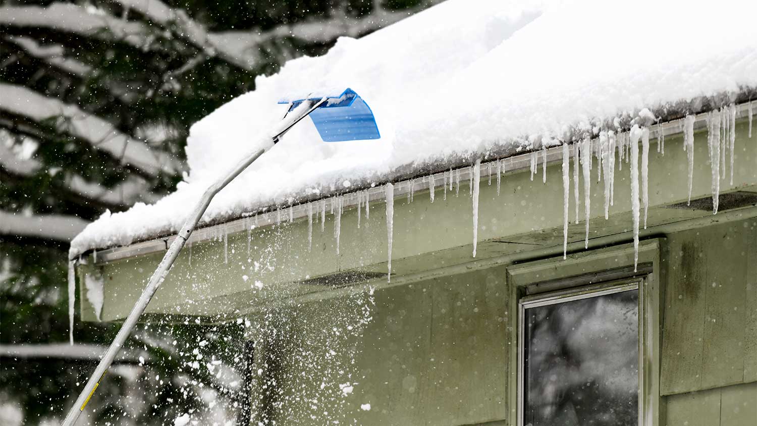 A roof rake clearing snow off roof