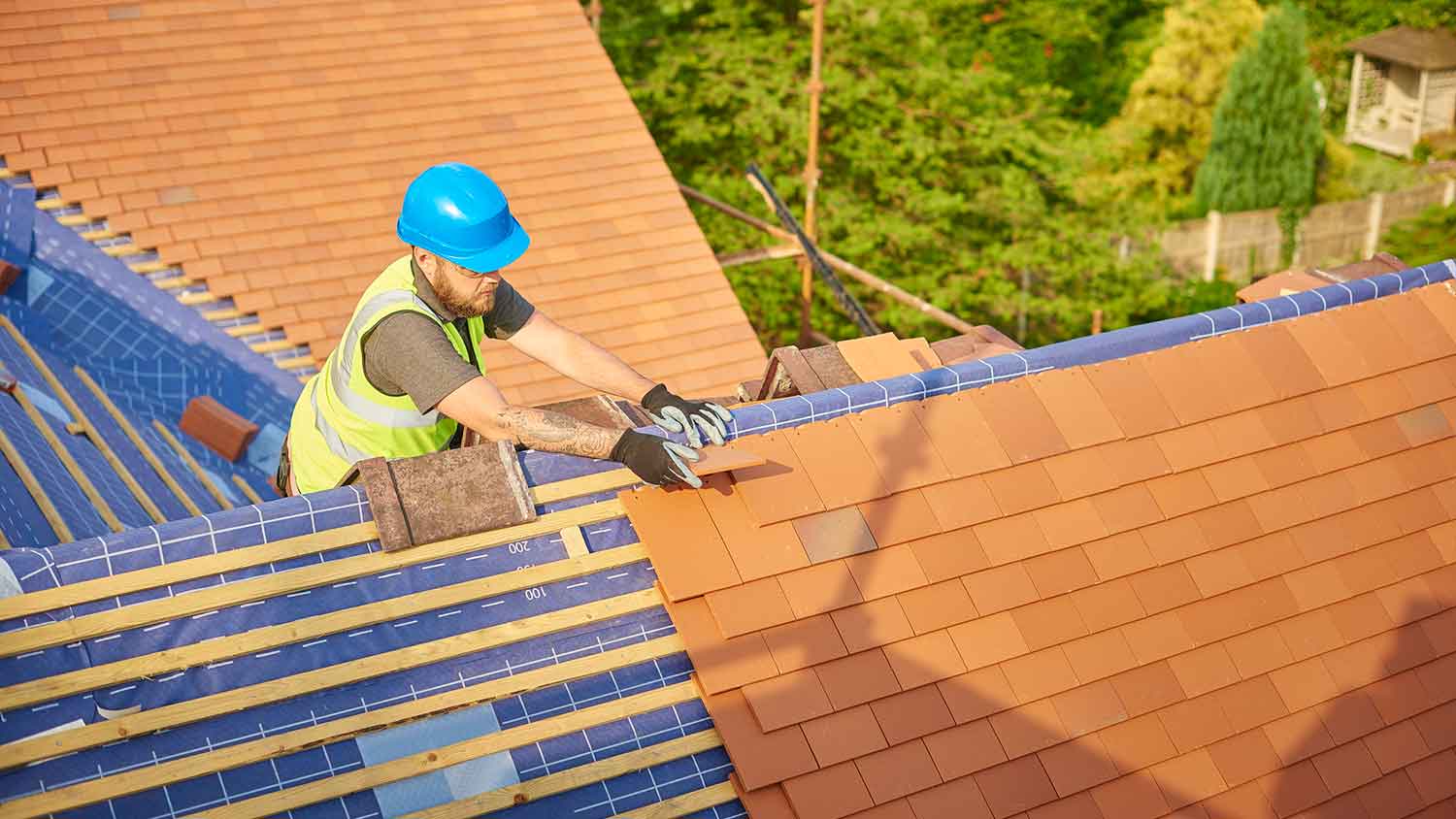 Roofing contractor installing clay roof tiles