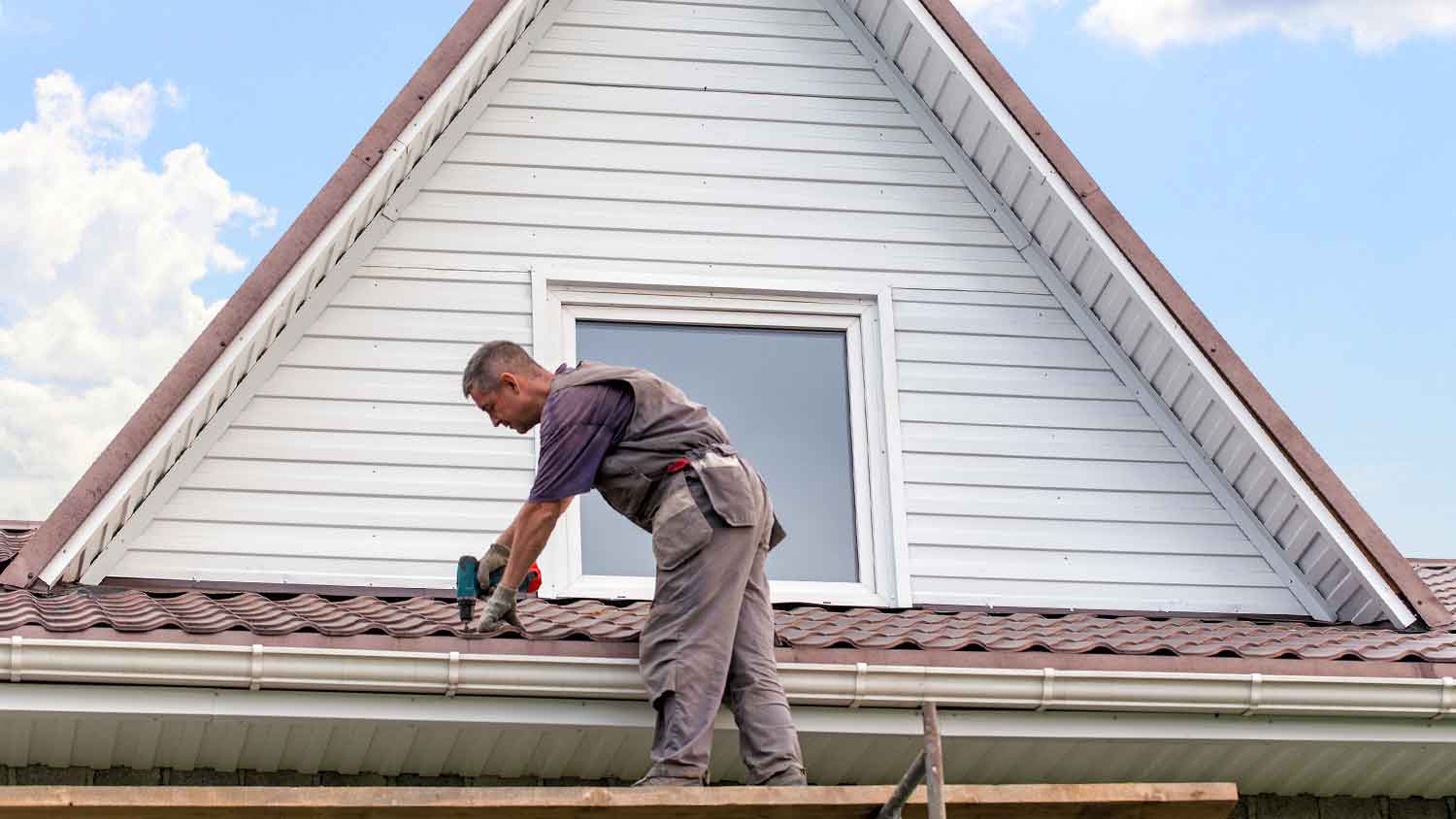 Professional roofer repairing the roof of a house