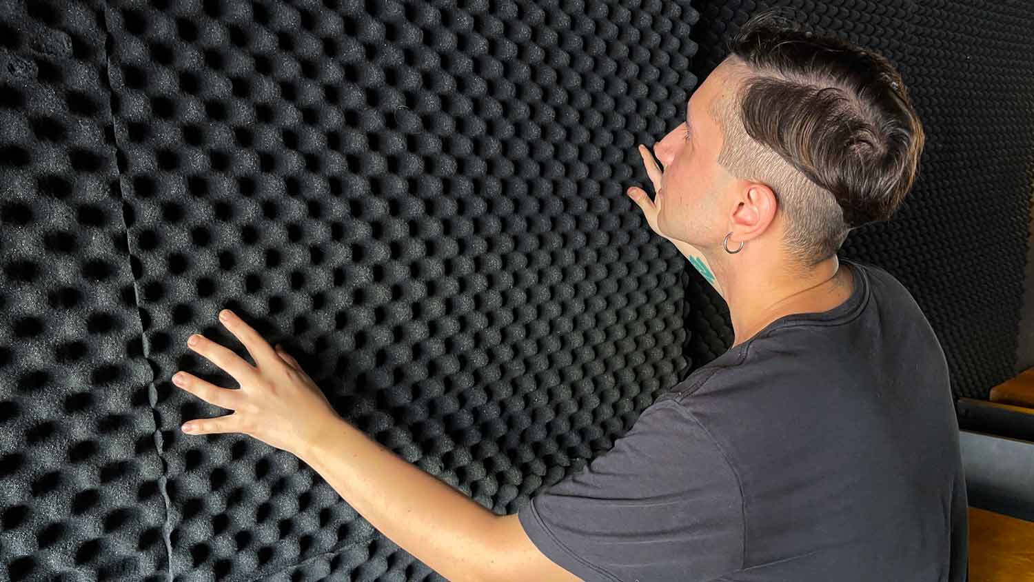man installing acoustic foam in room