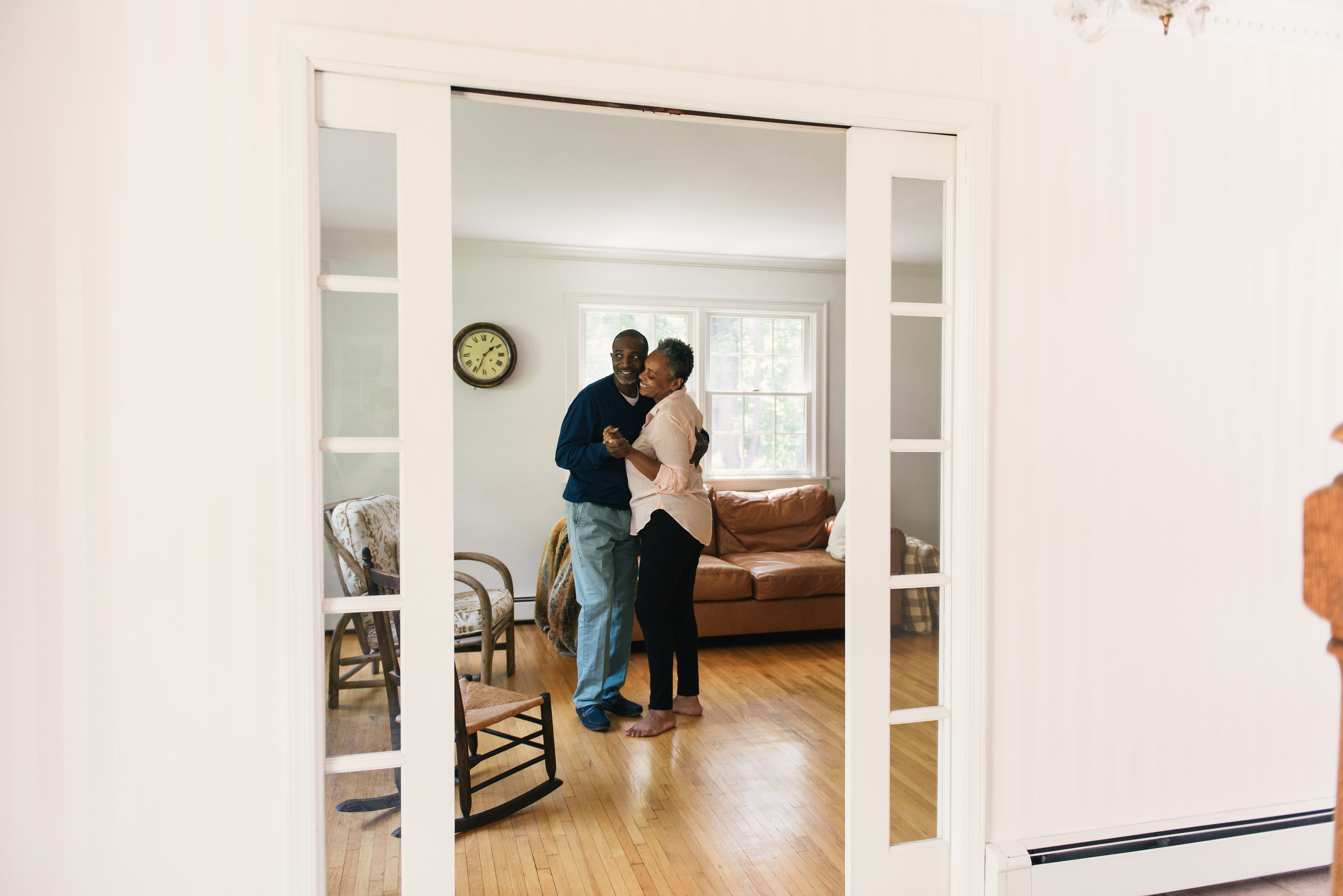 Couple dancing in a living room with pocket doors