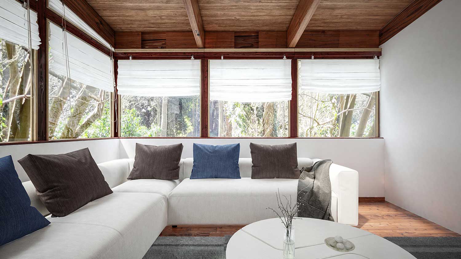 Living room with exposed wood beams and view of the forest