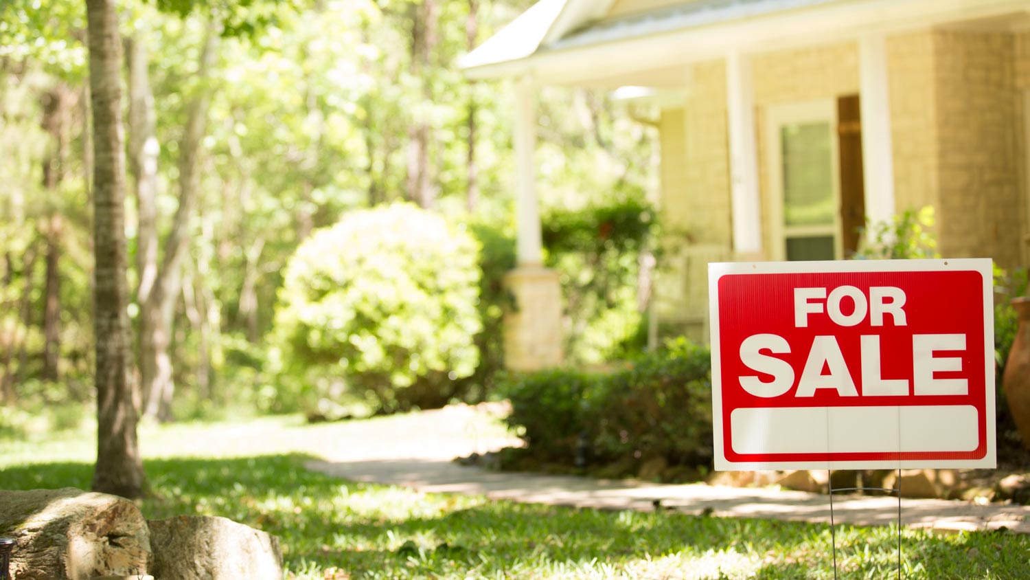 A sale sign in front of a house