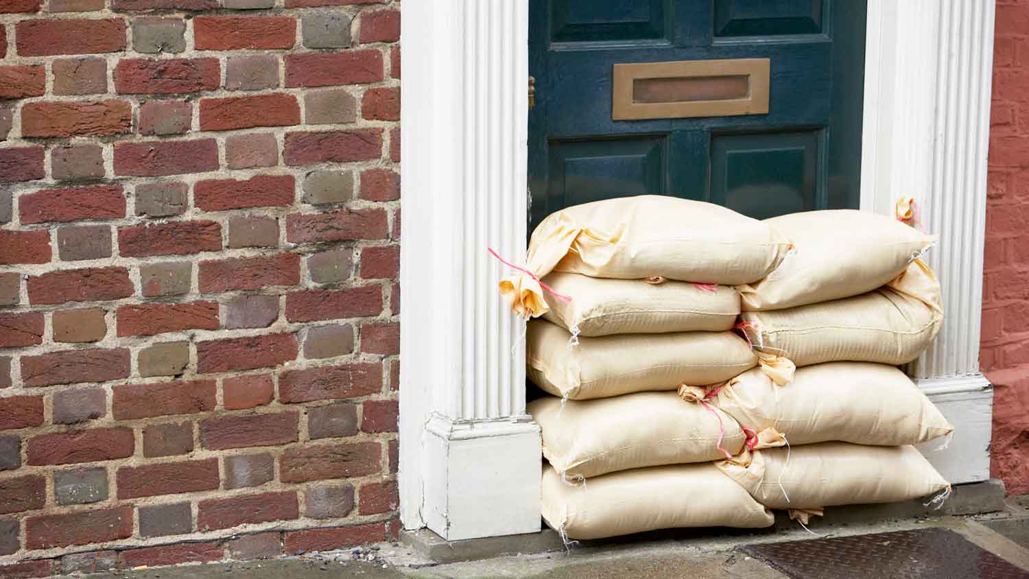 Sandbags placed in front of a house’s front door to prevent flooding