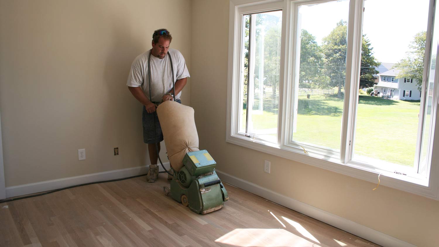 man sanding wood floor