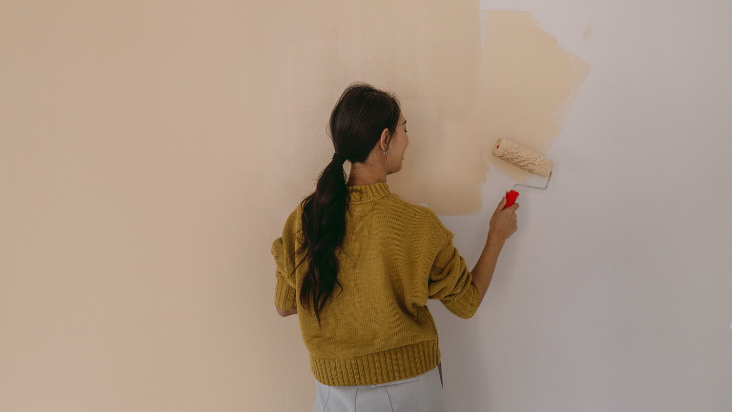 A woman's painting her own apartment