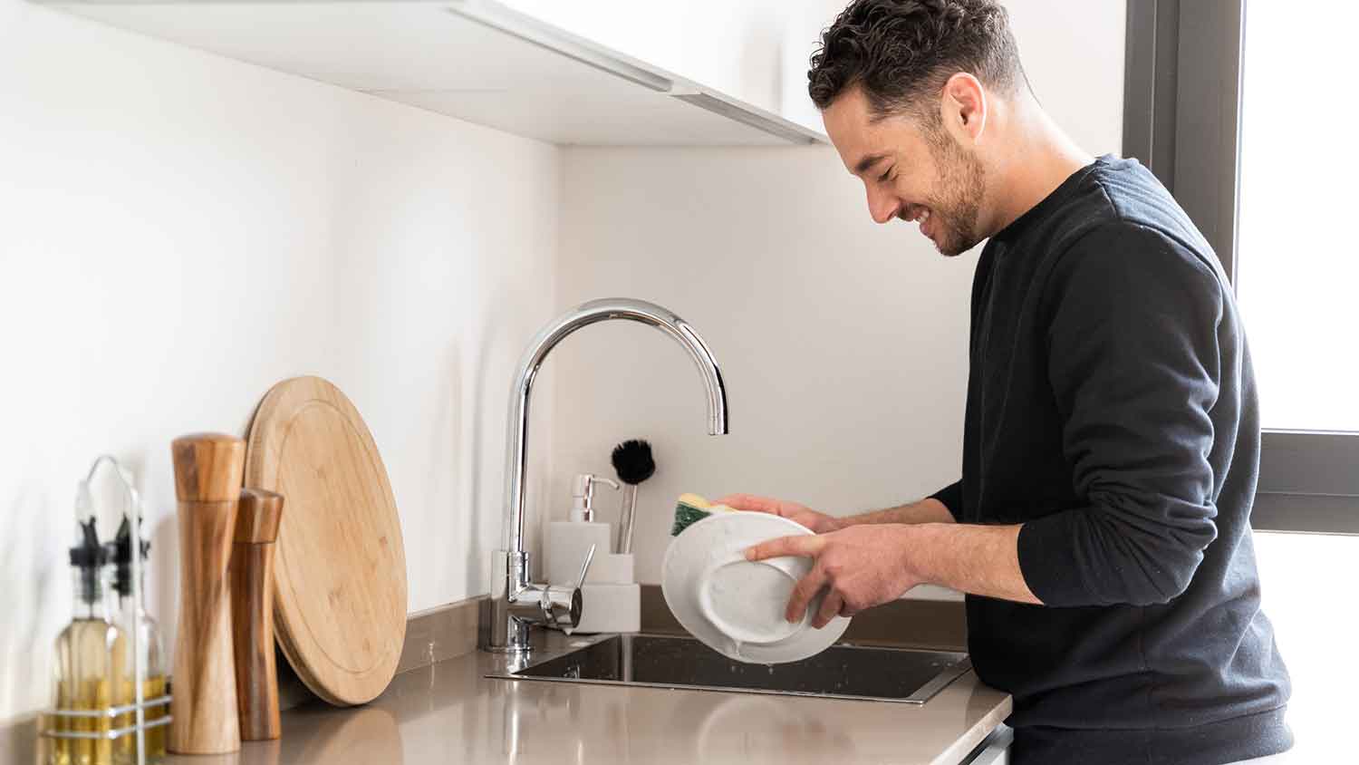 Man using kitchen sink to wash dishes