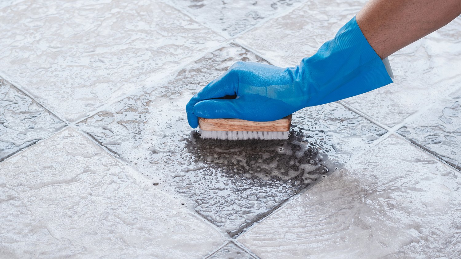 person scrubbing tile floors