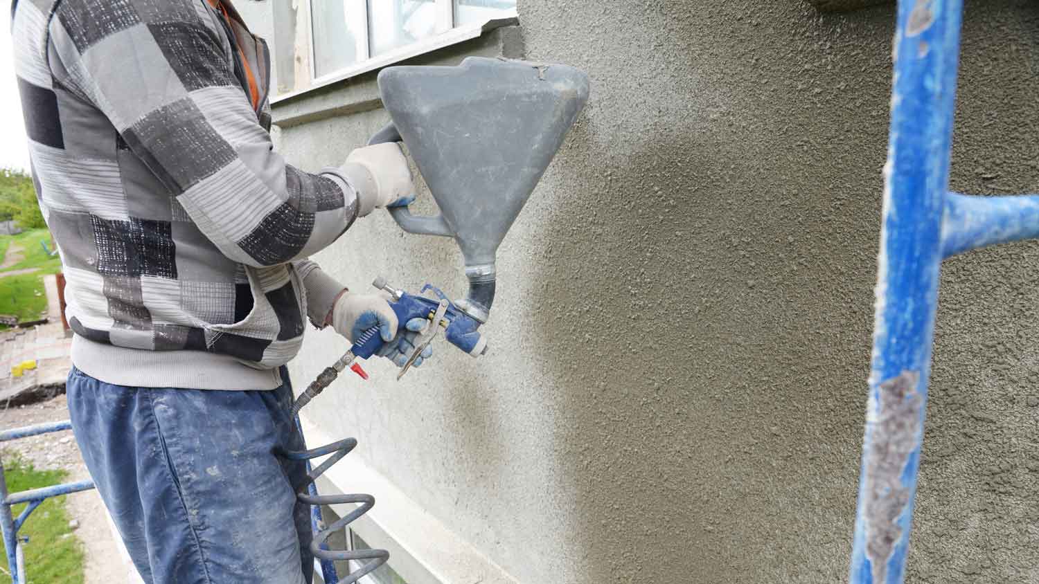 man applying sealant to stucco exterior  