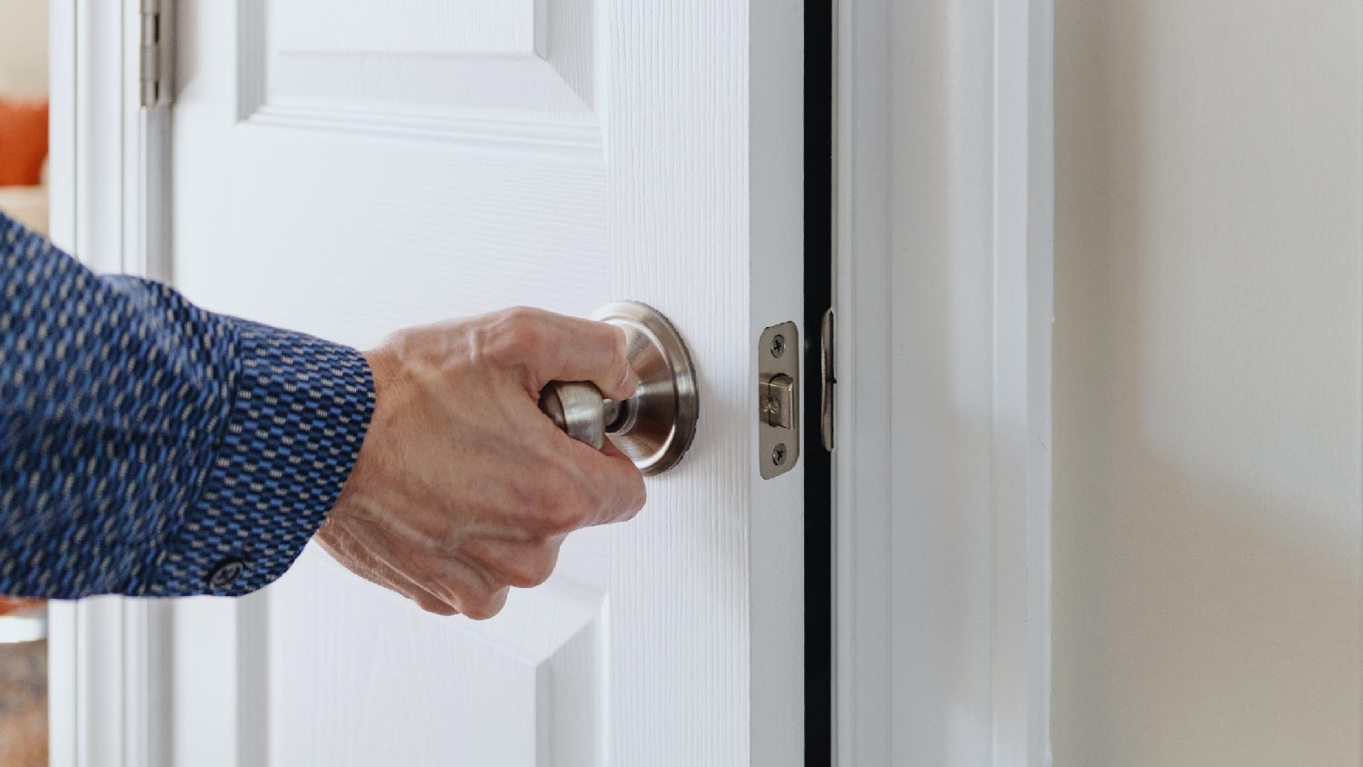 A senior man opening a door