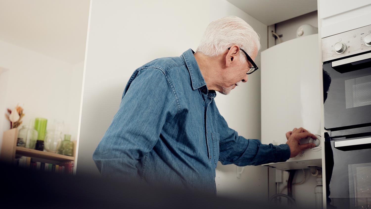 A senior man turning on a water heater