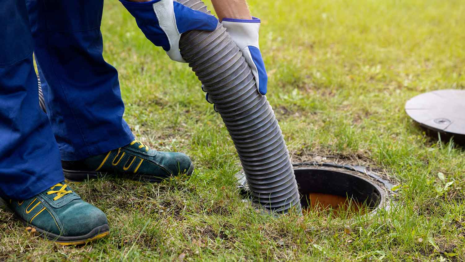 Worker pumping house septic tank