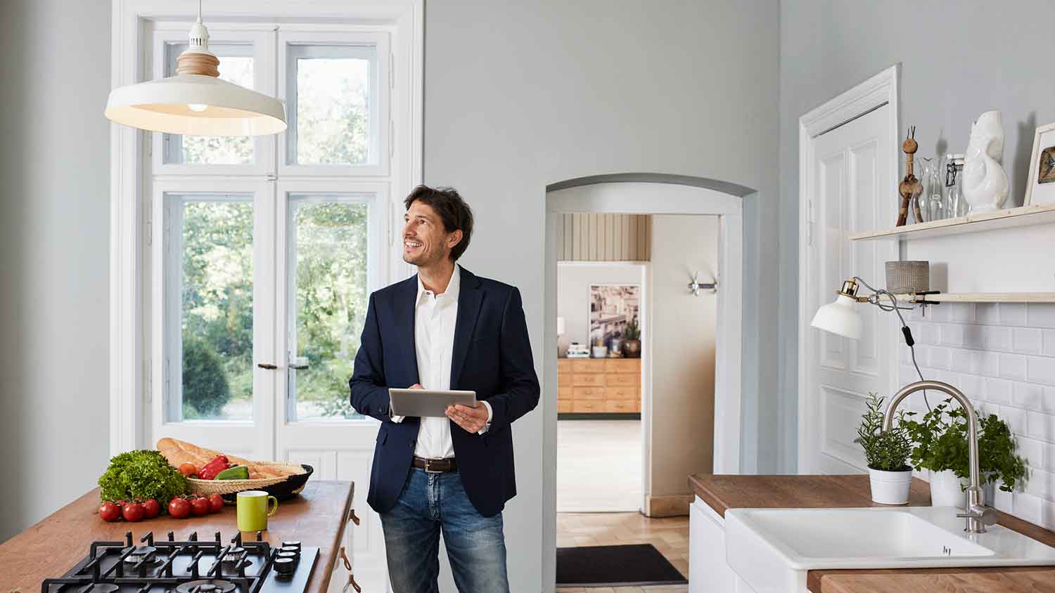 Man using tablet to setup smart lighting in the kitchen