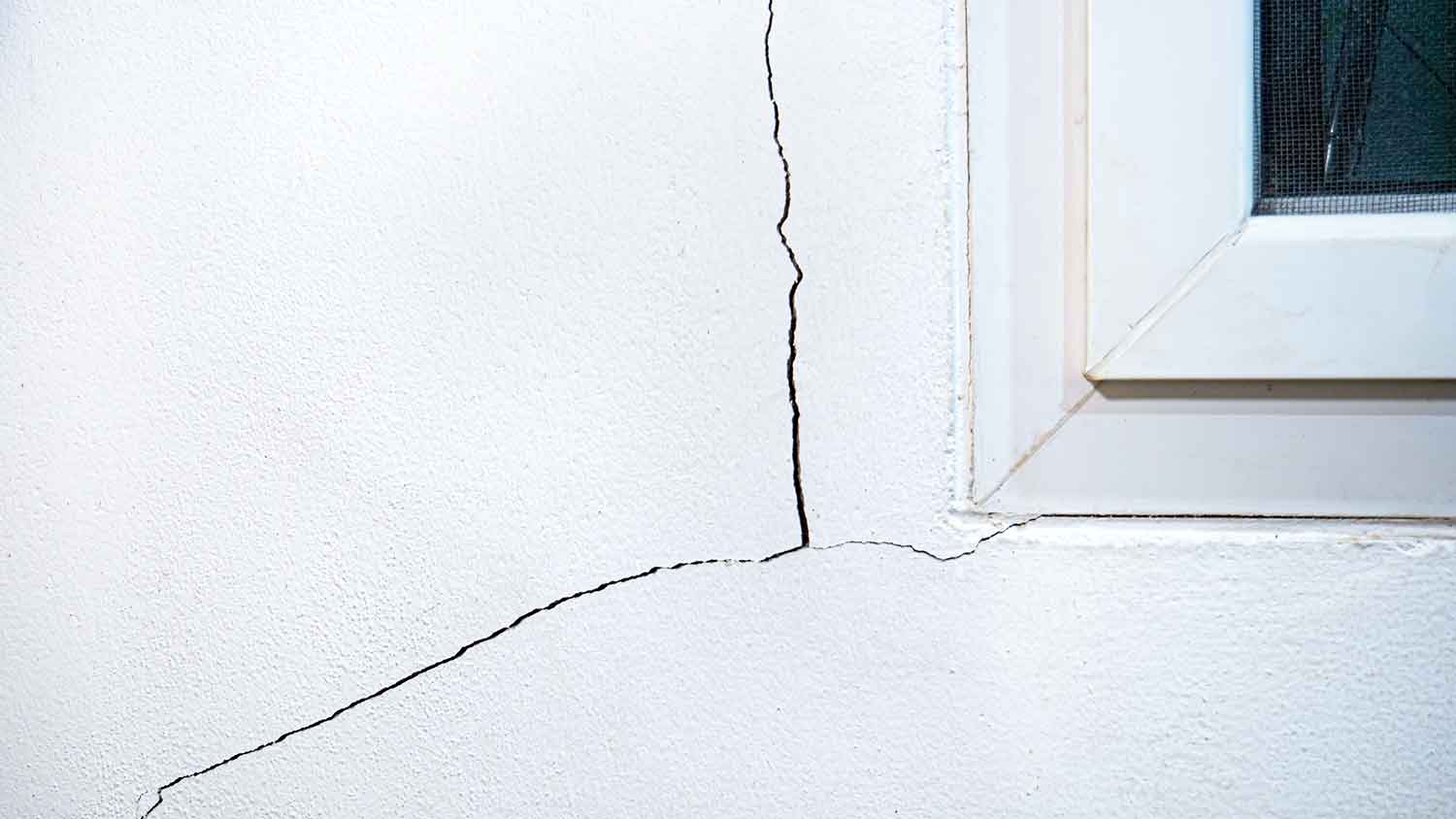 Settling crack in a concrete wall close to the window