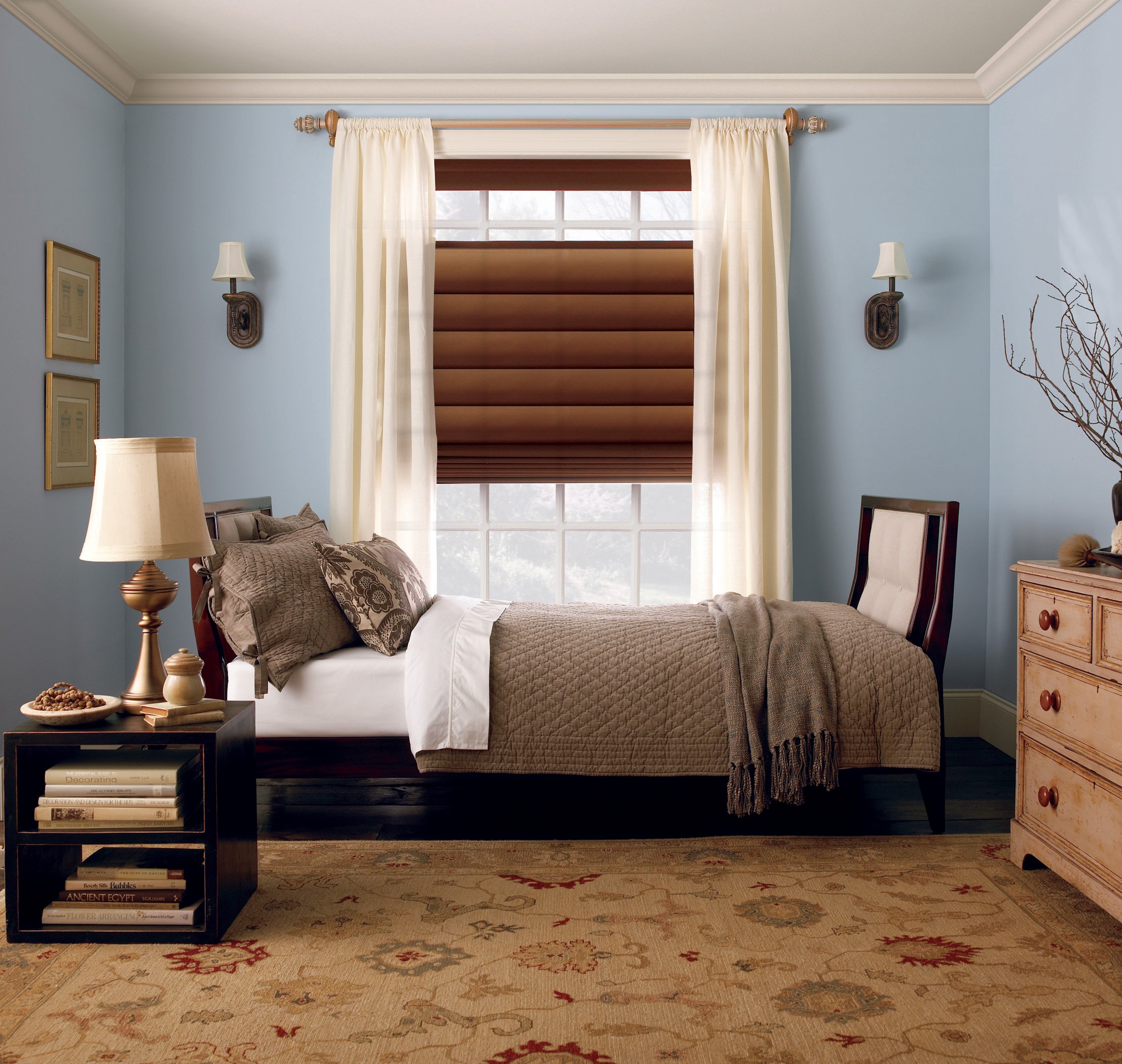 roman shades layered with drapery in bedroom