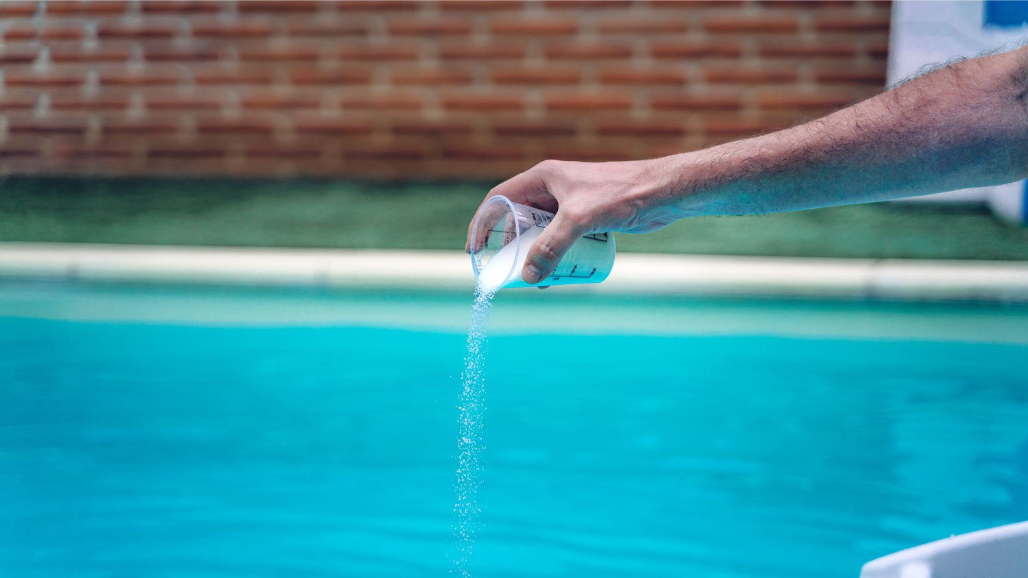 person pouring shock and swim treatment