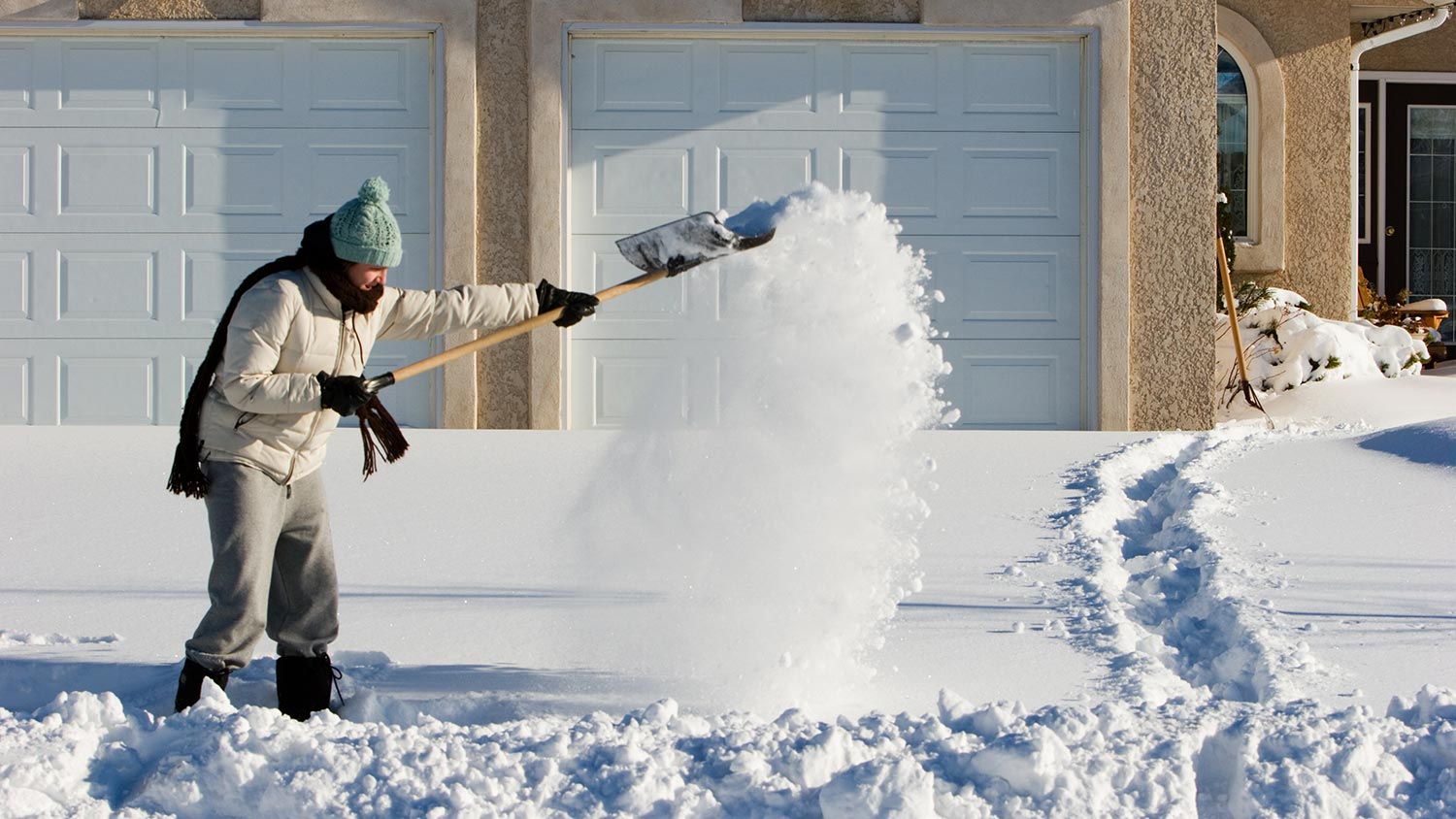 Person shoveling snow in a driveway 